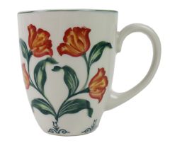 Mok groene bladeren met oranje tulpen