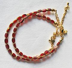 Armband transparant wijnrode kralen met goudkleurige rand